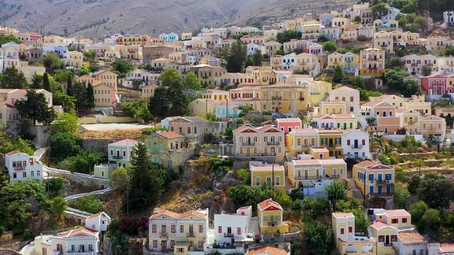 View on Symi (Simi) island harbor port, classical ship yachts, houses on island hills, Aegean Sea bay. Greece islands holidays vacation travel tours from Rhodos island. Symi, Greece,  Dodecanese.