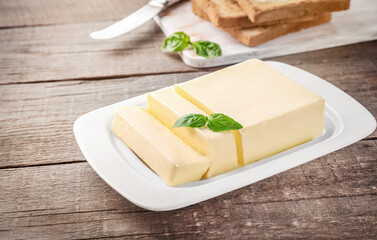 Cut block of fresh butter on wooden table