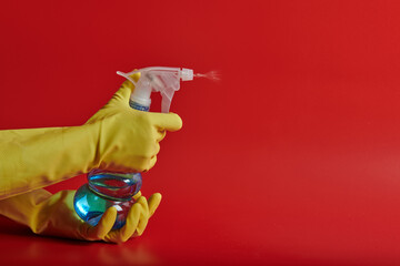 yellow gloves on a red background with a spray bottle