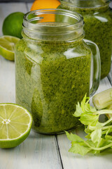 Healthy green smoothie with spinach in glass jars.