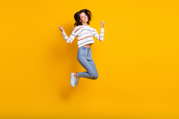 Fototapeta na wymiar Full size photo of young excited woman happy smile jump up celebrate win victory fists hands isolated over yellow color background