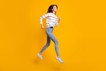 Full length profile side photo of young girl happy smile jump run hurry sale isolated over yellow color background