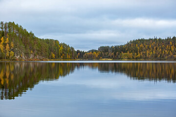 Reflection of a forest on the lake surface during autumn foliage in Finnish nature, Northern Europe