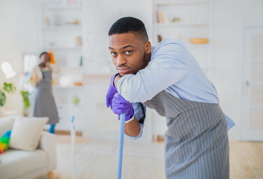 Millennial Black Guy Feeling Tired Of Too Much Domestic Work, Cleaning His Apartment With His Girlfriend, Copy Space