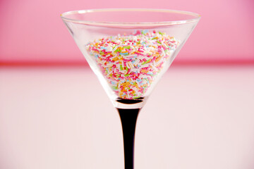 birthday cocktail concept, martini glass filled with multicolour candies