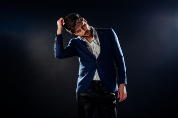 Fashion male model looking serious while standing on a black background