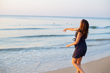 Fototapeta na wymiar The girl throws a coin into sea