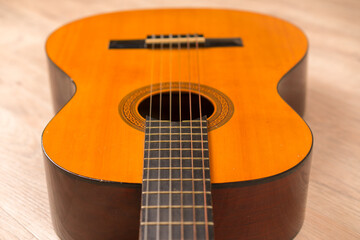 Obraz premium Classic six-string acoustic guitar on a wooden base. Selective focus.