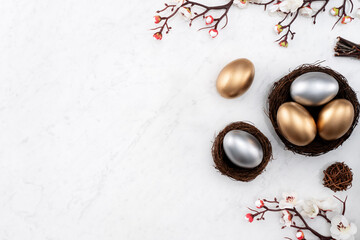 Fototapeta na wymiar Design concept of Golden and silver Easter eggs in the nest with white plum flower.