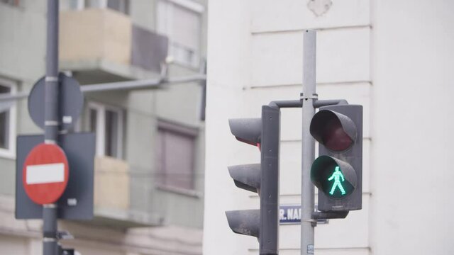 Slow motion close up of green traffic lights changing.