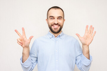 Bearded man shows fingers eight, white background, copy space