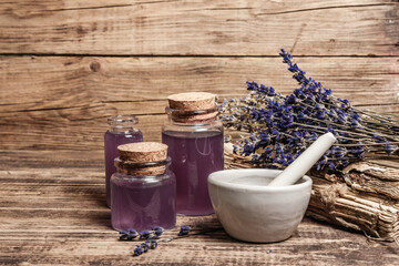 Dried lavender flowers in a in a mortar and pestle with bottle of essential lavender oil or infused...