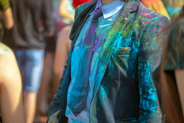 Fototapeta na wymiar young man sprinkled with multi-colored powder at the Festival of colors.