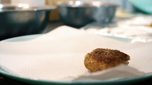 Meatballs are placed on a white napkin so that it absorbs excess oil. Kitchen life hack. Close up slow motion footage.
