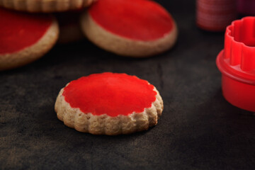 Red coated cookies on an old rusty metal surface