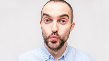 Young bearded man sending air kiss, close up, copy space, 16:9