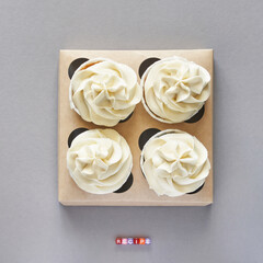 Paper box with cream cupcake. Birthday sweet bakery. Cookies four pack. Yummy buttercream dessert. Wedding party food. Grey background. Holiday recipe