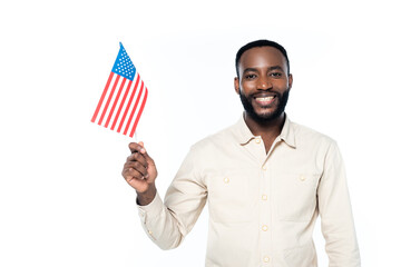 cheerful african american man smiling at camera while holding small flag of usa isolated on white