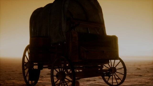 canvas covered retro wagon in desert at sunset