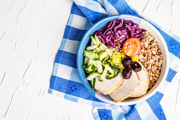 Buddha Bowl with buckwheat, baked lean pork, red cabbage, cucumber, tomato, olives, flax seeds