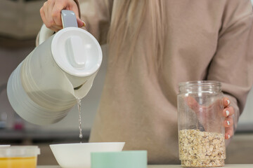 Mom prepares oatmeal with honey in the kitchen.