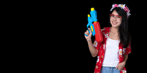 Portrait cheerful young Asian woman holding water gun Smiling and having fun playing in the water Songkran festival, Thailand. isolated on black background. Thai New Year's Day.