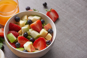 Bowl of healthy fresh fruit salad. fresh fruit and vegetable salad, healthy breakfast. bowl of oat granola with yogurt. Orange juice drink.