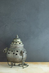 Antique metal incense burner on gray background