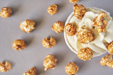 Milky cream cupcake. Birthday sweet bakery. Cookies. Yummy buttercream dessert. Wedding party food. Grey background. Holiday recipe. Anniversary gourmet. One pieces. Caramel popcorn