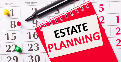 On the calendar is a white card with the text ESTATE PLANNING. Nearby is a red notepad and a marker. View from above