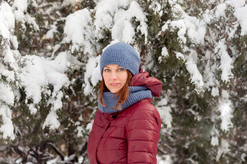 Winter portrait of a girl. Girl in warm clothes. Portrait of a woman in a winter park.