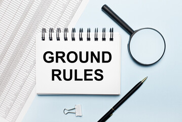 On a light blue background, reports, a magnifying glass, a pen and a notebook with the text GROUND...