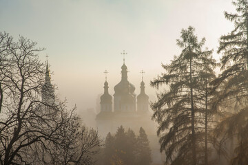 Orthodox church in the morning fog at dawn in the middle of the park