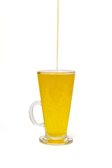 Sunflower oil in a glass on a white background.