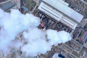Pipes with white smoke. Pipes of a city gas boiler room with white smoke against a sky. Top view from a drone.