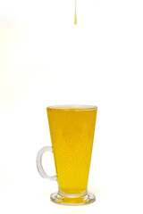 Sunflower oil in a glass on a white background.
