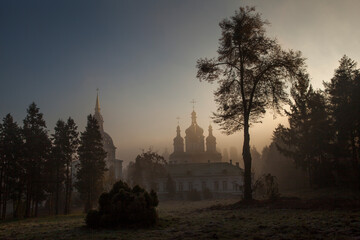 Orthodox church in the morning fog at dawn in the middle of the park