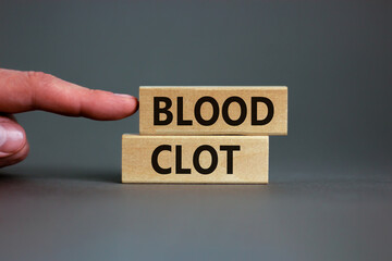 Medical and and blood clot symbol. Wooden blocks with words 'blood clot'. Beautiful grey background. Doctor hand. Medical and and blood clot concept. Copy space.