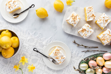 Top down view of servings of lemon meringue squares ready for eating with more squares on a marble...