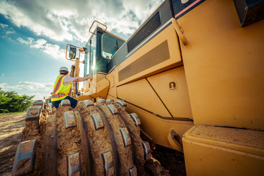 excavator and worker on a sunny day on construction site