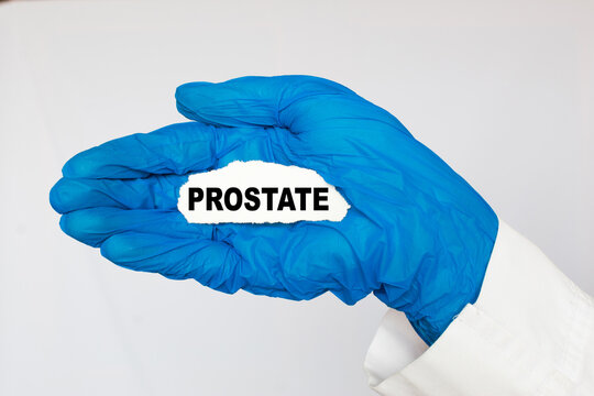 The doctor's blue - gloved hands show the word PROSTATE - . a gloved hand on a white background. Medical concept. the medicine