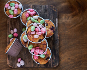 Cupcakes decorated with Easter chocolate eggs. Wooden background. Top view
