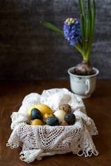 Spring Easter composition with Easter quail eggs in a box with an openwork napkin. Side View.