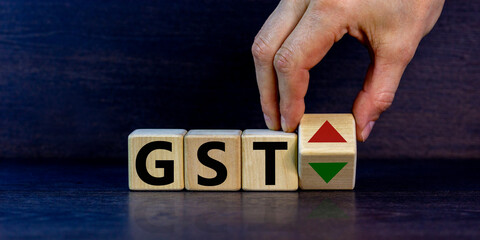 GST, goods and services tax symbol. Businessman holds a cube with up and down icon. Word 'GST'....