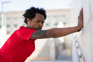 Afro athletic man stretching before exercise.