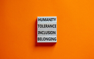Obraz premium Humanity, tolerance, inclusion, belonging symbol. Wooden blocks with words humanity, tolerance, inclusion, belonging on beautiful orange background. Tolerance, humanity, inclusion, belonging concept.