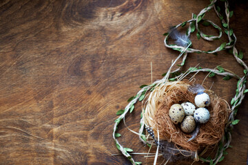 Easter basket with quail eggs on wooden background with place for text. Side View.