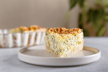 Piece of the traditional French quiche Lorraine pie with feta cheese and spinach served in plate ready to eat. Close-up.