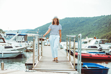 Naklejka premium woman in white fashion luxury view walking by dock boats on background