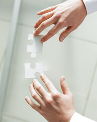 close-up . businessman connecting two pieces of a puzzle.